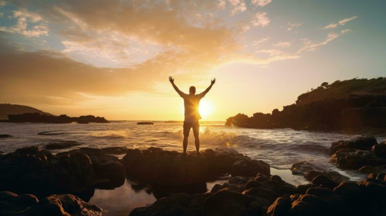 happy-man-enjoying-life-on-beach-rocks-by-the-ocean-with-arms-wide-open-silhouette-concept-free-photo